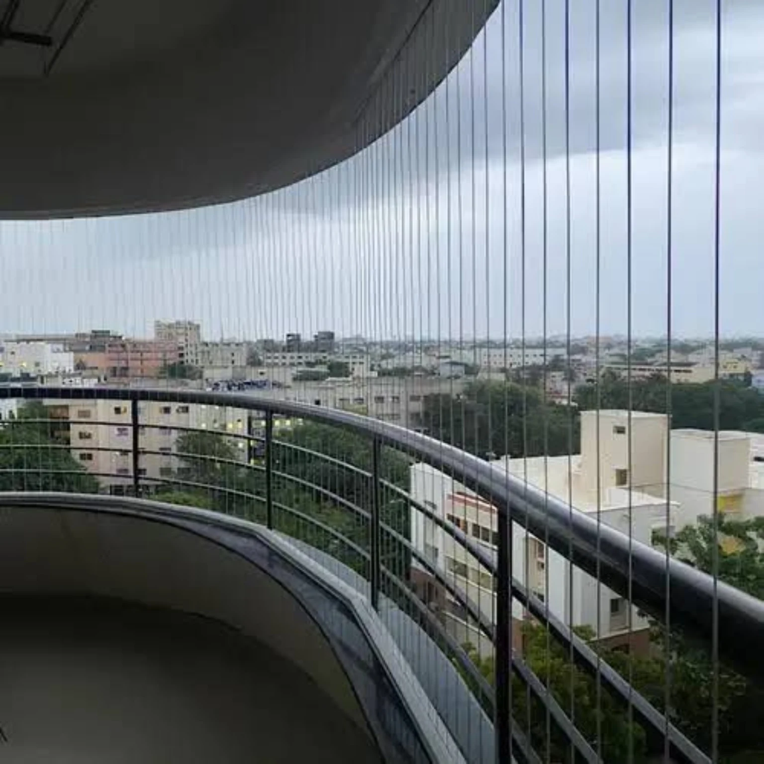 Invisible grill cables following the curve of a residential balcony